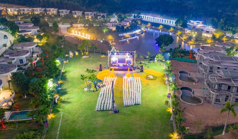 an aerial view of a large , well - lit park with a stage and people walking around at Ivory Villas & Resort