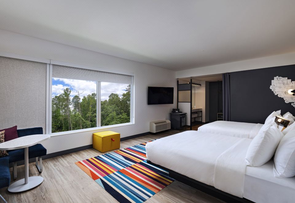 a modern bedroom with two beds , one on each side of the room , and a television mounted on the wall at Aloft Little Rock West