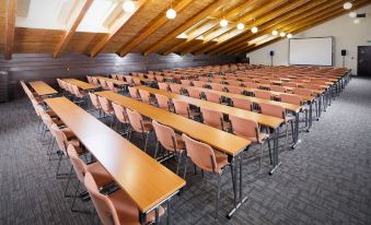 a large , empty conference room with rows of wooden tables and chairs arranged in a row at Home2 Suites by Hilton Atlanta Marietta