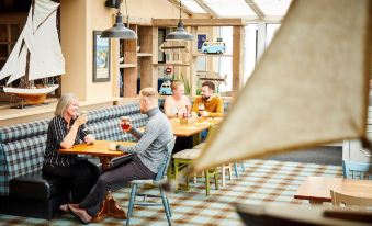 a group of people sitting at a table in a restaurant , enjoying each other 's company at Trearddur Bay Hotel