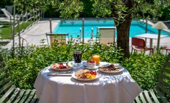 a dining table set with a variety of food items , including multiple plates , bowls , and cups at Hotel San Marco