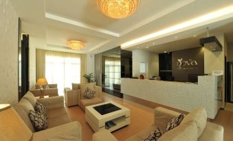 a spacious and well - lit hotel lobby with comfortable seating , a reception desk , and a large chandelier at Nova Highlands Hotel