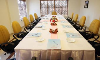 a long dining table set for a formal event , with multiple place settings and napkins on the table at Hotel Palace Inn