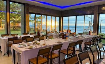 a long dining table set for a large group of people , with multiple chairs arranged around it at Blues River Resort