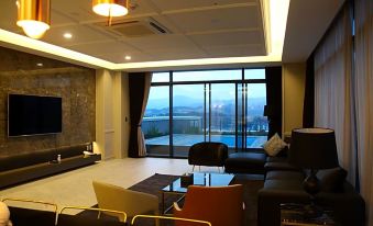 a modern living room with large windows offering a view of the city , and various furniture pieces at Am Hotel