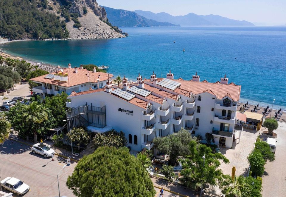 aerial view of a white hotel surrounded by trees and the ocean in montenegro at The Diplomat Hotel