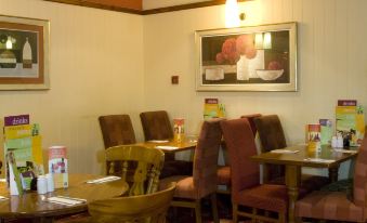 a dining room with tables and chairs arranged for a group of people to enjoy a meal together at Premier Inn Hull West