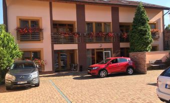 a brick building with multiple cars parked in front of it , including a red car at Hotel City