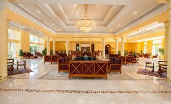 a large , ornate lobby with marble floors , wooden furniture , and a chandelier hanging from the ceiling at Jolie Ville Hotel & Spa Kings Island Luxor