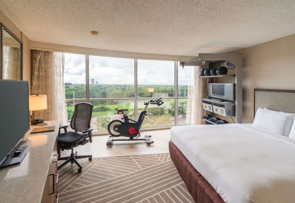 a hotel room with a bed , desk , and a window , offering a view of the city at Hilton Memphis