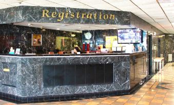 "a reception desk with a large black marble wall and the word "" registration "" above it" at Oh St Joseph Resort Hotel