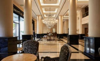 a large , elegant lobby with a marble floor and a chandelier hanging from the ceiling at DiplomaticHotel
