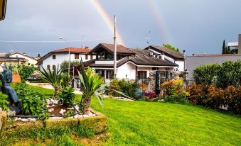 a man standing in a yard with a double rainbow in the sky above him at Nest