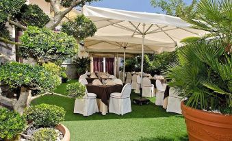 an outdoor dining area with tables and chairs set up for a wedding reception , surrounded by lush greenery at Leonardo's