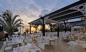 an outdoor dining area at a restaurant , with tables and chairs set up for guests to enjoy a meal at Adrián Hoteles Roca Nivaria