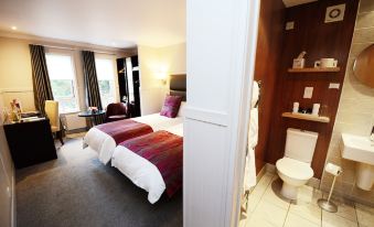 a hotel room with two beds , one on the left side and the other on the right side of the room at Glynhill Hotel & Spa Near Glasgow Airport