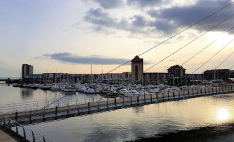 a marina with numerous boats docked , including sailboats and motorboats , as well as people enjoying the view at Ice House Apartments