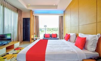 a large bed with a red blanket and white sheets is in a room with wooden walls at Thaiasia Goldensea Resort