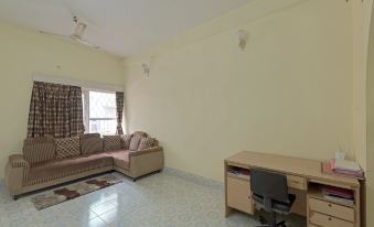 a living room with a couch , a chair , and a desk in front of a window at Radical