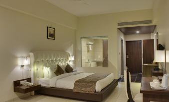 a large bed with a wooden headboard and footboard is in a room with a chair , table , and mirror at Hotel Lake View