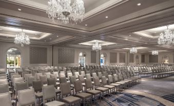 a large , empty conference room with rows of chairs and chandeliers hanging from the ceiling at The Ritz-Carlton, Laguna Niguel