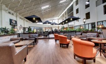 a large , modern lobby area with multiple couches and chairs arranged in various positions , creating a comfortable seating area for guests at The Atrium Hotel on Third