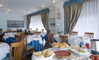 a dining room with a table set for breakfast , featuring a variety of pastries and desserts at Hotel President