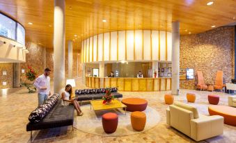 a modern hotel lobby with various seating options , including couches and chairs , as well as a reception desk at Mur Faro Jandia Fuerteventura & Spa