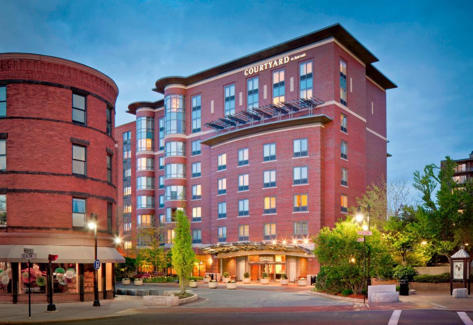 a large brick building with a large sign on the front , located in a city setting at Courtyard by Marriott Boston Brookline