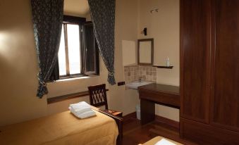 a hotel room with two beds , a window , and a bathroom with a sink and mirror at Villa Palazzola