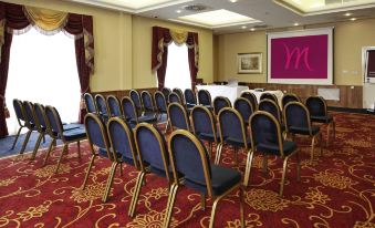 a conference room with rows of chairs arranged in a semicircle , and a tv mounted on the wall at Letchworth Hall