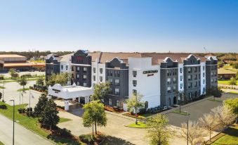 an aerial view of a fairfield inn & suites hotel surrounded by trees and other buildings at Courtyard Houma