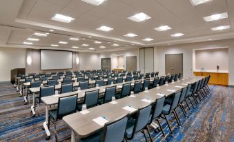 a conference room with rows of chairs arranged in a semicircle , and a projector on the wall at Hyatt House Provo/Pleasant Grove