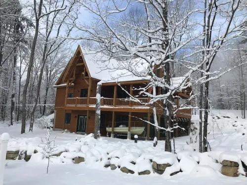 Luxury Log home steps from private beach in Meredith on Lake Winnipesaukee.