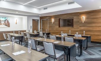 a conference room with wooden tables , chairs , and water bottles , ready for a meeting or presentation at Hampton Inn & Suites Bridgeview Chicago