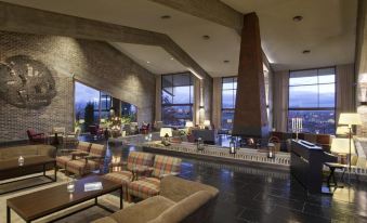 a large , modern hotel lobby with multiple couches , chairs , and tables arranged in an open space at Parador de Santo Estevo