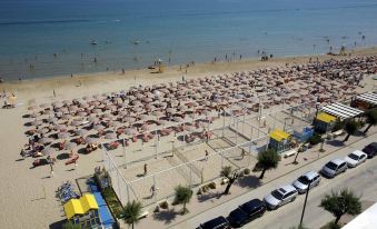 a large group of people gathered on a beach , enjoying the sun and each other 's company at San Marco