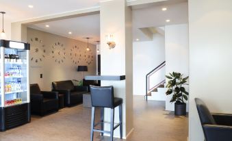 a modern living room with a bar area and stairs leading to the second floor at Fosshotel Westfjords