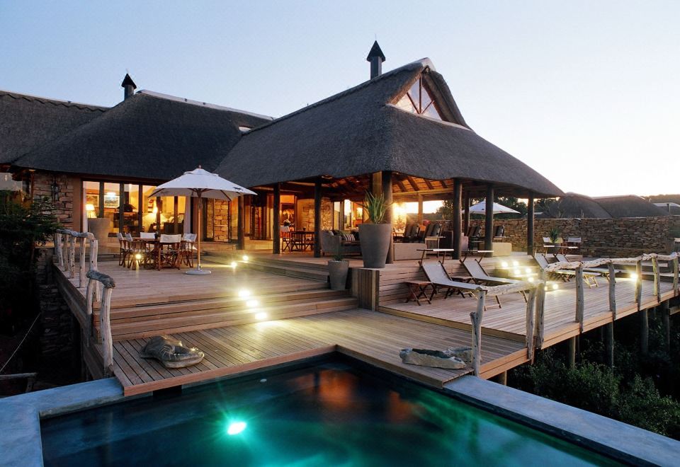 a luxurious beach house with a pool and a hot tub , situated on stilts over the ocean at Pumba Private Game Reserve