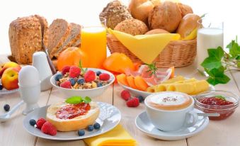 a table is set with a variety of breakfast items , including bread , fruit , and a cup of coffee at Punta del Este Arenas Hotel