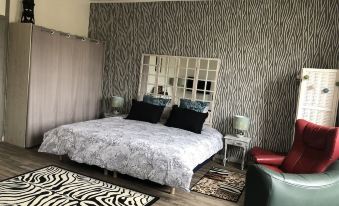 a bedroom with a large bed , black and white patterned walls , and zebra print rug at Le Numero 15