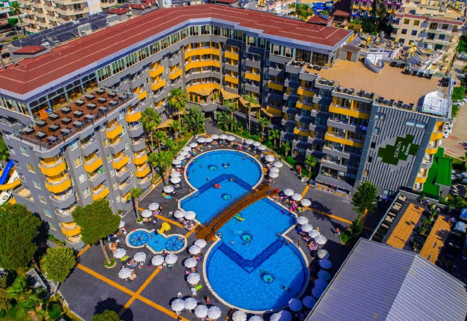 aerial view of a large hotel with multiple pools and umbrellas , surrounded by palm trees at Senza Grand Santana Hotel