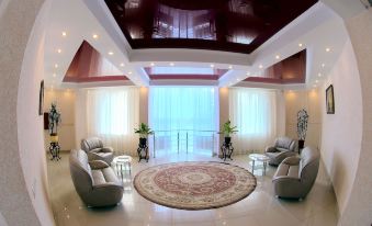 a modern , spacious living room with high ceilings , multiple couches , and chairs arranged around a circular rug at Sonata