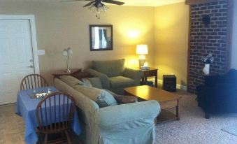 a cozy living room with two couches , one on the left and one on the right , along with a dining table and chairs at A Mighty Oak B&B