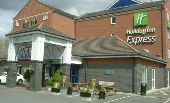 a holiday inn express hotel with its brick building and surrounding outdoor seating area , under cloudy skies at Holiday Inn Express Newcastle Gateshead