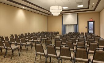 a large conference room with rows of chairs arranged in a semicircle , ready for a meeting at Hilton Garden Inn Akron