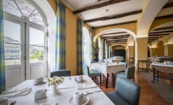 a dining room with a long table set for breakfast , surrounded by chairs and a window at The Vintage House - Douro
