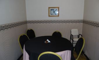 a dining room with a round table surrounded by chairs , and a painting on the wall at Hotel San Francisco