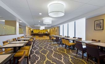 a large dining room with multiple tables and chairs arranged for a group of people at La Quinta Inn & Suites by Wyndham Springfield MA