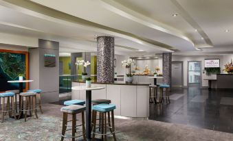 a modern bar area with several stools and tables , creating an inviting atmosphere for patrons at Crowne Plaza Dublin - Blanchardstown